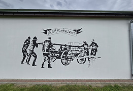 mural na ścianie budynku garażowego przedstawiający sikawkę konną obsługiwaną przez strażaków  (photo)