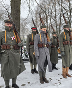 widok na stojących członków grupy rekonstrukcyjnej na cmentarzu (photo)